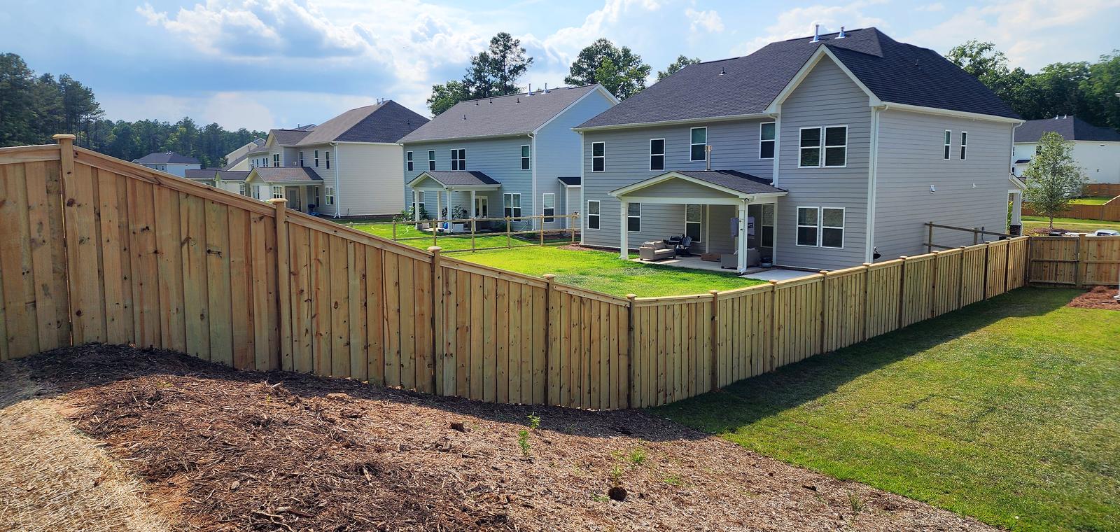 Wood privacy fence with cap and trim running along a backyard in the Midlands of South Carolina