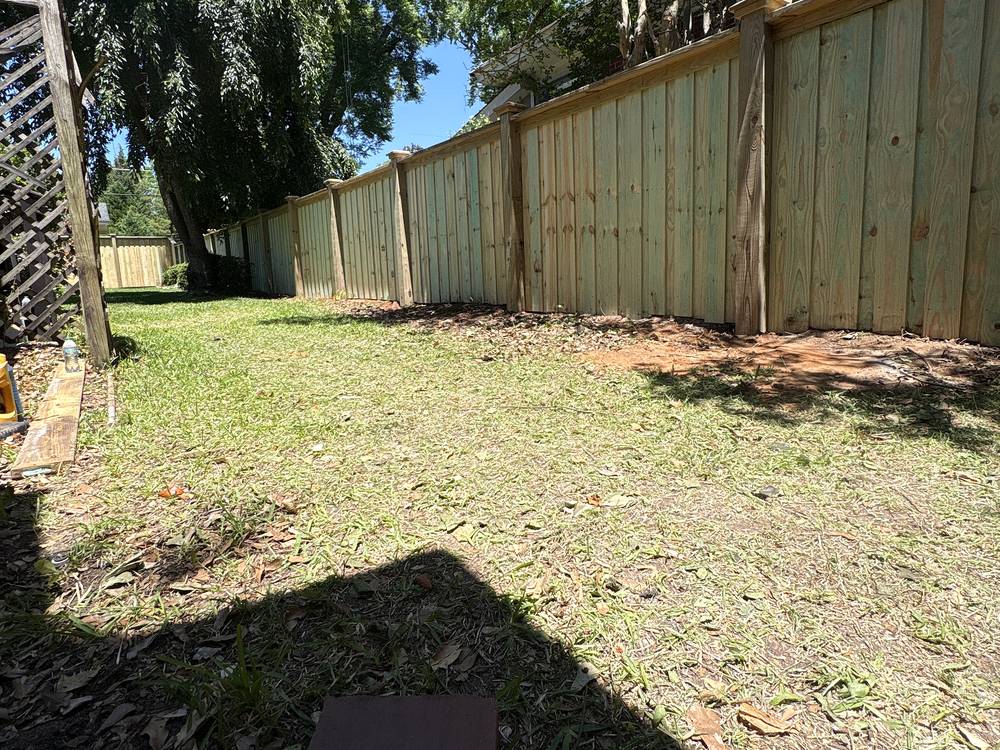 Wood privacy fence with cap and trim running along a backyard in Irmo, South Carolina