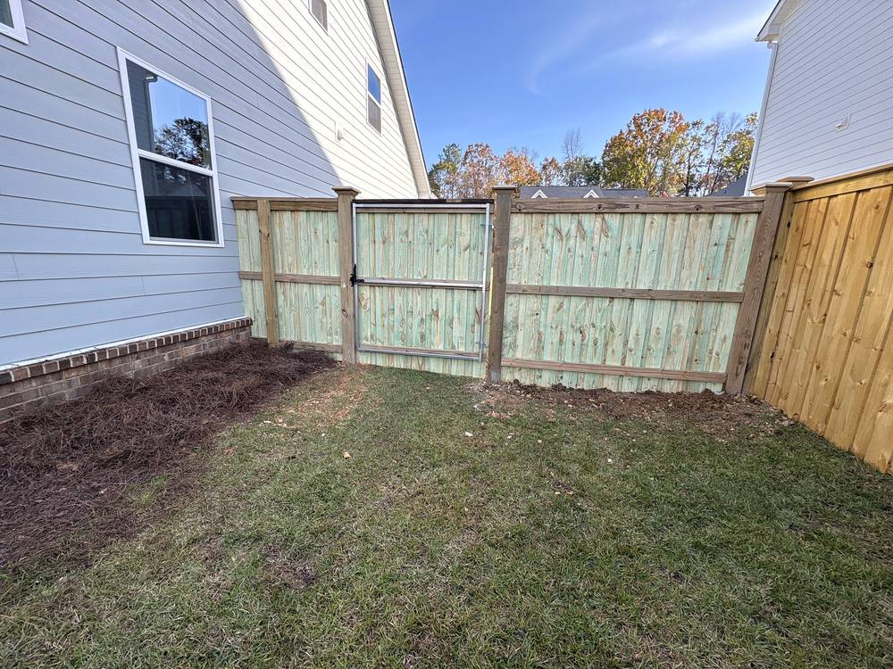 Wood cap and trim fence and walk gate along a side yard in Irmo, SC