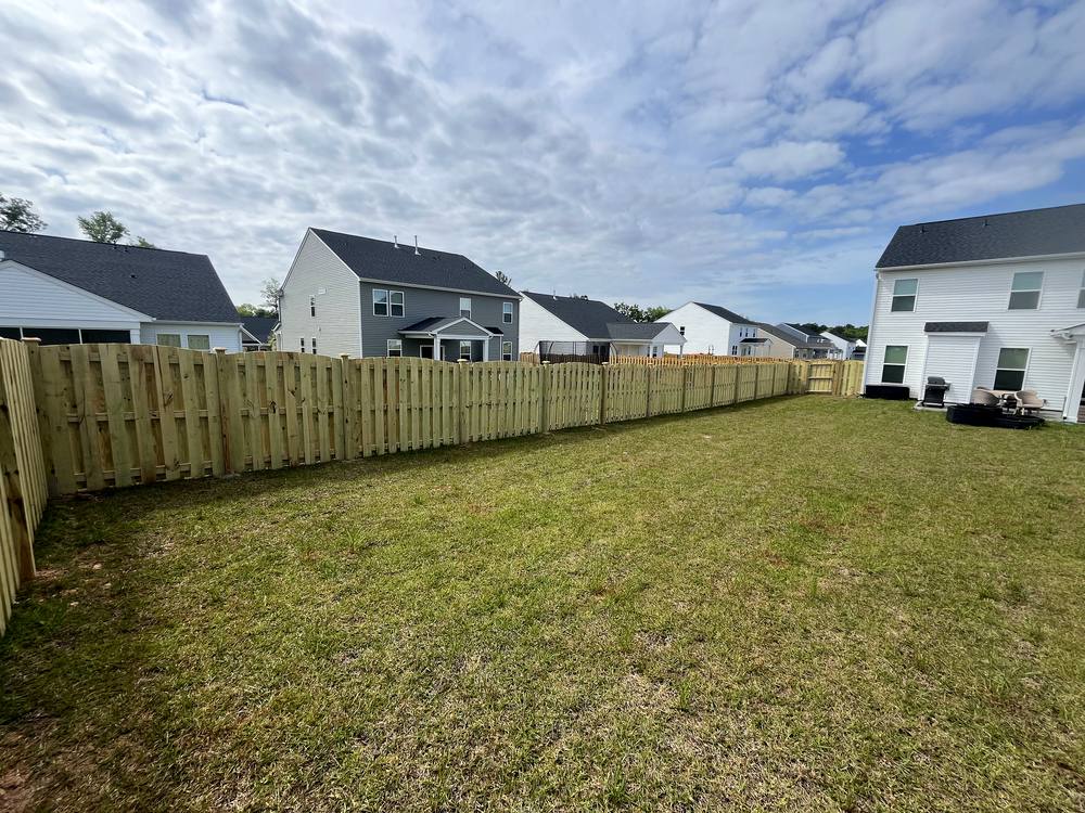 Wood picket fence enclosing a wide open backyard in the Midlands of South Carolina