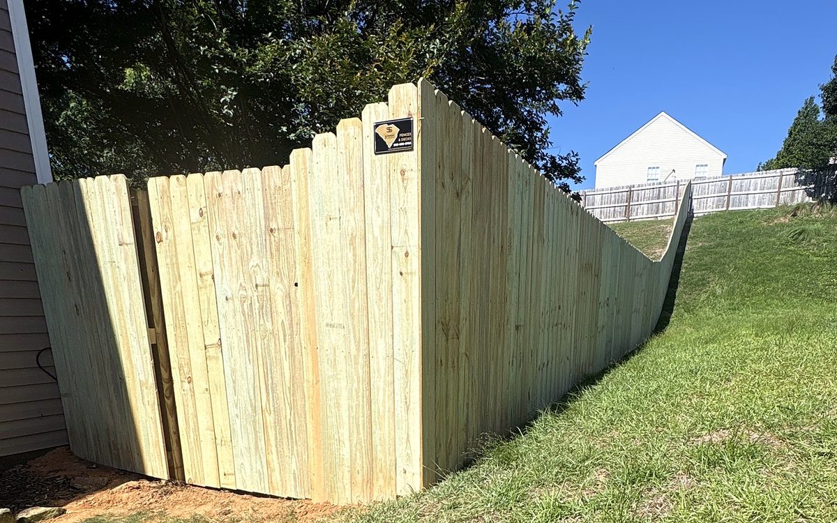 New wood privacy fence following a hill behind a home in Lexington, SC